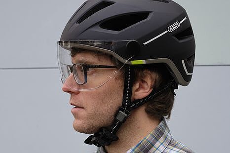 Ein Fahrradhelm mit Visier kann für Menschen mit Brille praktisch sein. Mann mit Brille und Fahrradhelm mit Visier